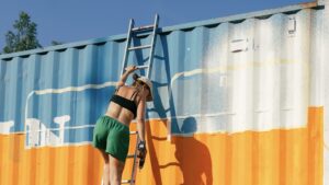 FLINTA* die vor einem blau-orangenen Container eine Leiter hochsteigt.